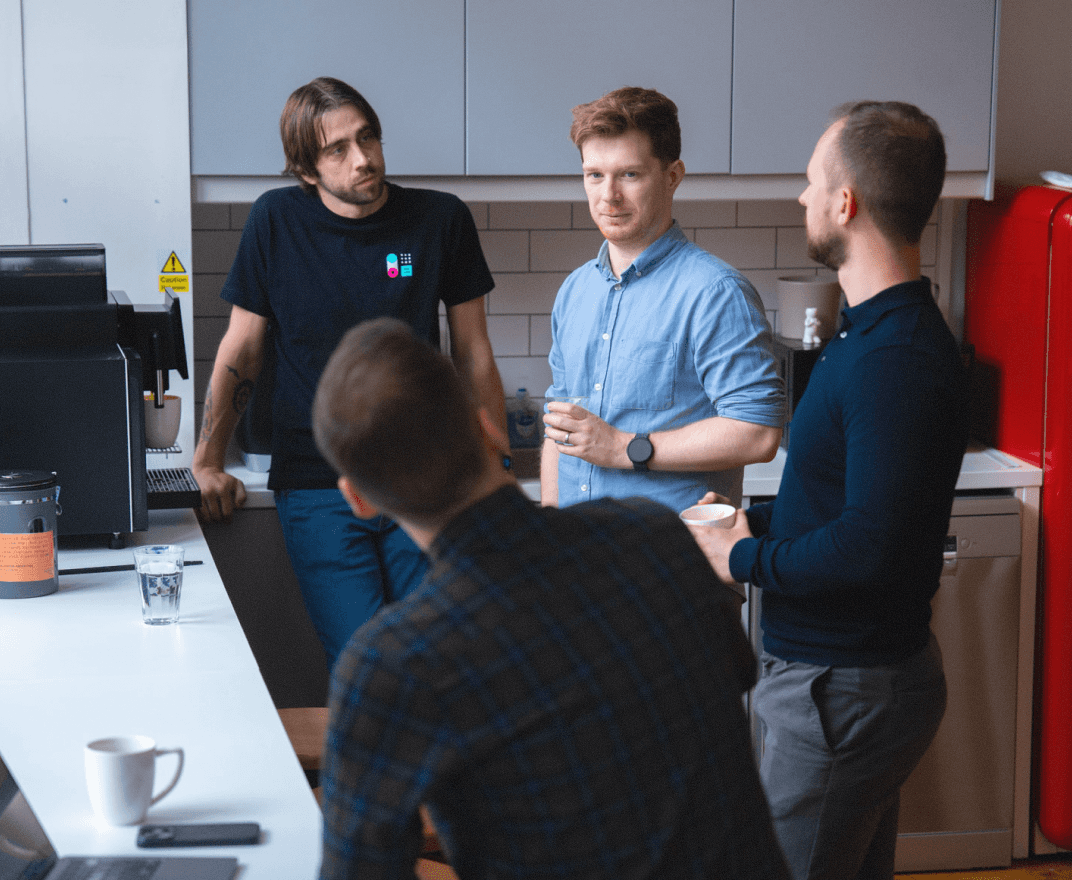 four Capsule team members talking