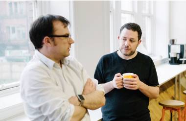 Dos miembros del equipo de Capsule charlando informalmente.