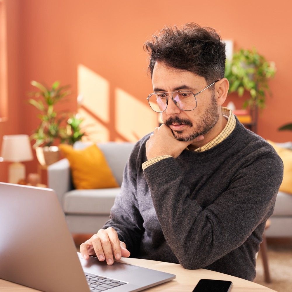 Un hombre mirando atentamente la pantalla de una laptop