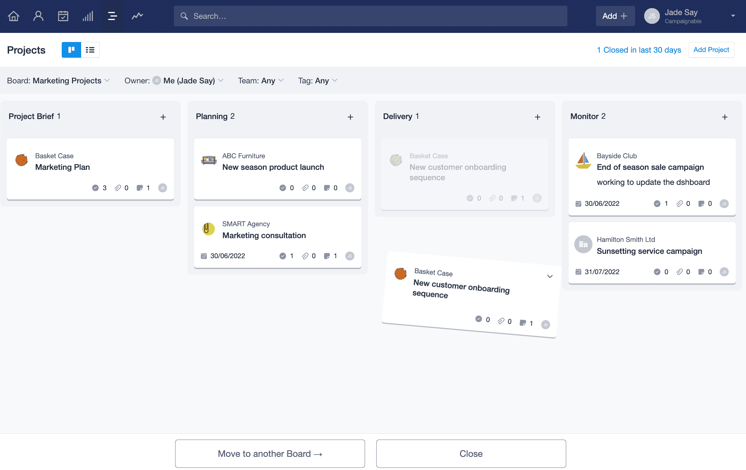 Project kanban view is displayed with a Project card being dragged towards the bottom of the page. Two buttons appear with the option to close the project or move it to another board