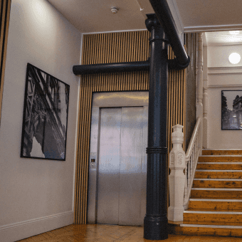 um membro da equipe do Capsule está trabalhando em um sofá no escritório.