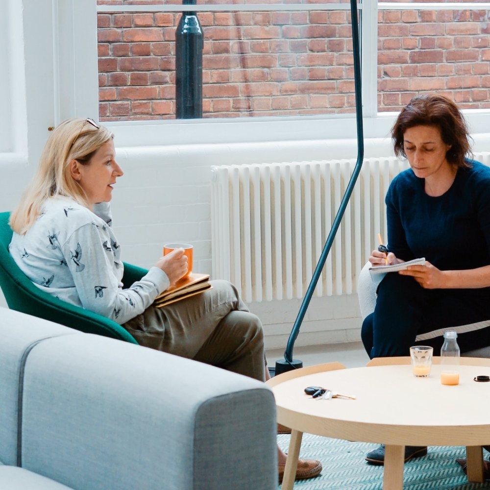 Two women in a break-out area discussing business