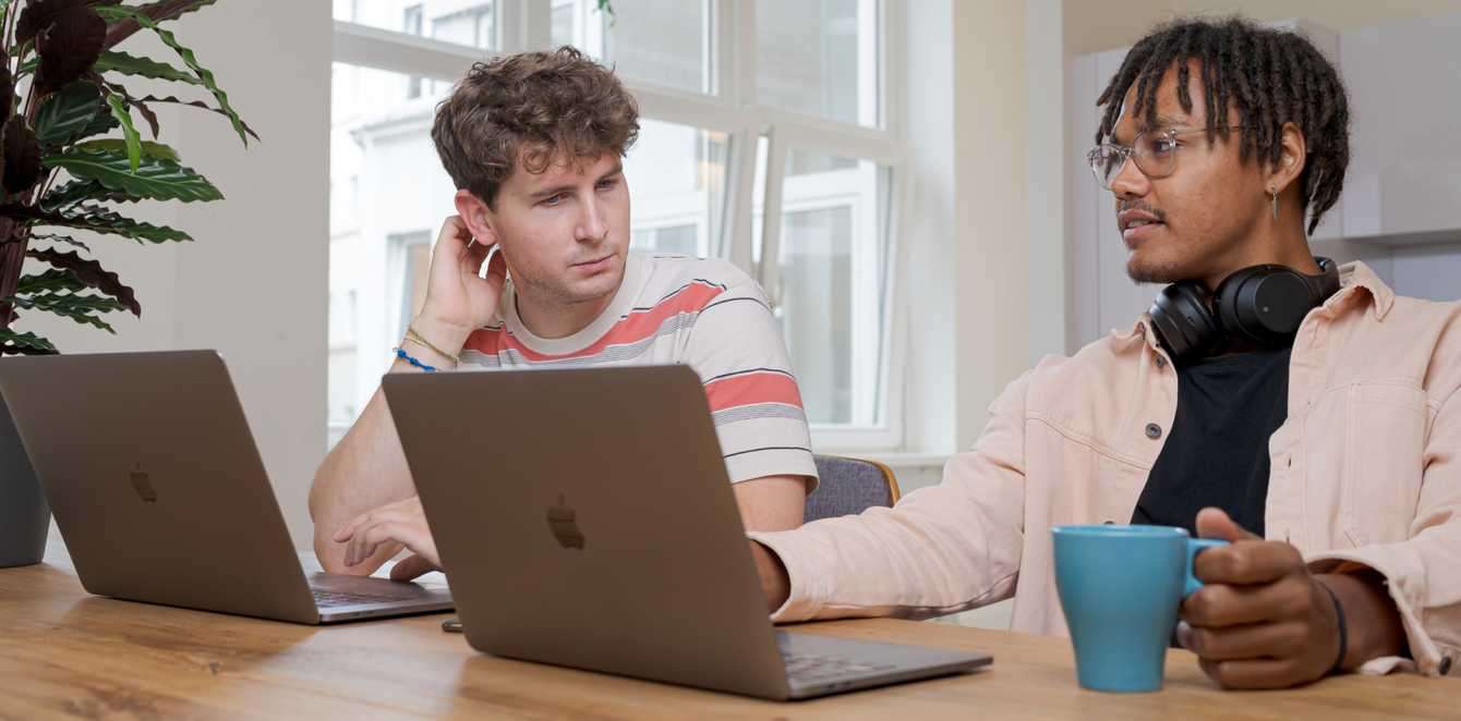 Two people working together on their laptops